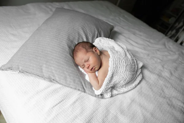 Time to sleep. Happy cute newborn child laying at the blanket at the cozy sofa while sleeping at home. Stock photo. Happy childhood concept