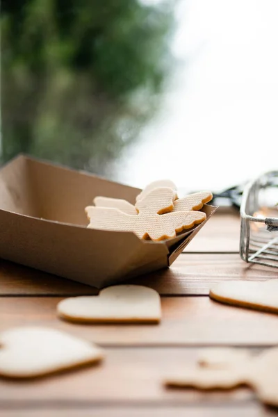 Pencerenin kenarında duran lezzetli bisküvilerin dikey görünümü ve arka planda kış manzarası. Tatlı kurabiye konsepti. Stok fotoğrafı