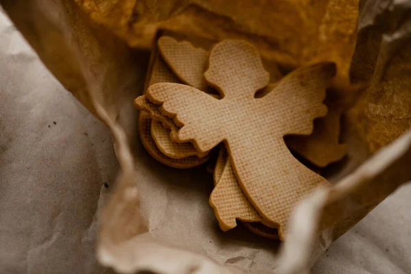 Noel melekleri. Bisküvileri, el işi karton kutunun üzerinde duran desenli bir Noel meleği gibi yakından izleyin. Tatiller ve tatlı kurabiye konsepti. Stok fotoğrafı