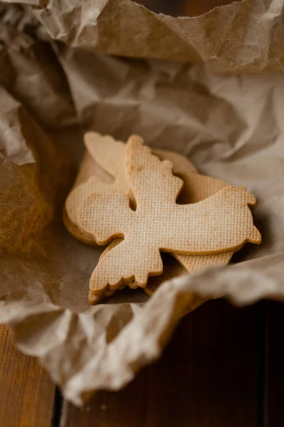 Ahşap pencere kenarındaki el işi karton kutunun yanında duran Noel meleklerinin lezzetli şekilli kurabiyelerinin yakın görüntüsü. Tatlı kurabiye konsepti. Stok fotoğrafı