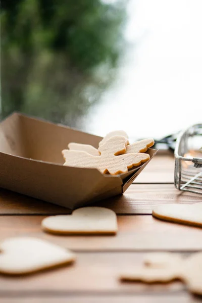 Pencerenin kenarında duran lezzetli bisküvilerin dikey görünümü ve arka planda kış manzarası. Tatlı kurabiye konsepti. Stok fotoğrafı