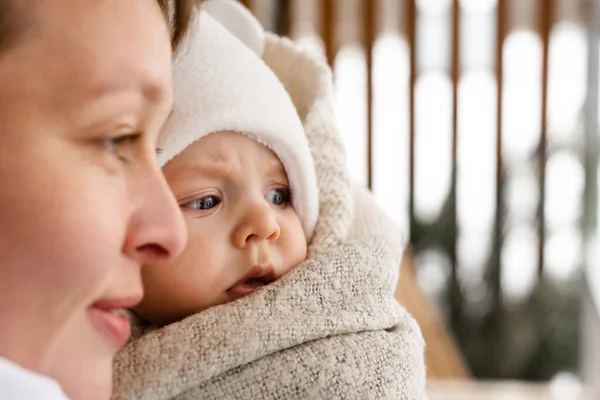 Zekice bir bakış. Küçük şirin bebeğin portre görüntüsü. Annesi onu ellerinden tutarken başka yere bakıyor. Oğluyla eğlenirken gülümseyen bir kadın. Stok fotoğrafı