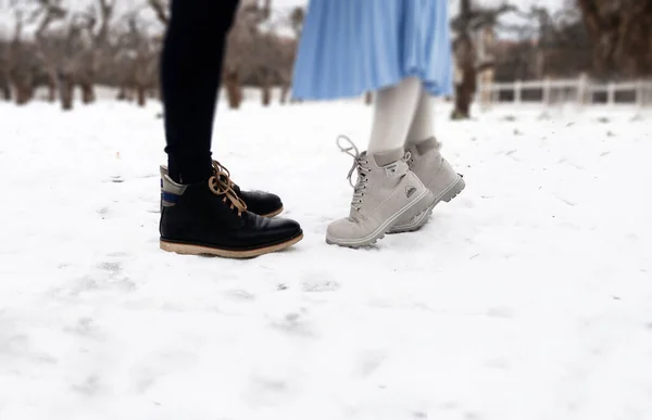 Aşk tarihimiz. Birbirini seven genç çiftin bacakları karların önünde birbirine bağlanmış. İlişkiler konsepti. Stok fotoğrafı