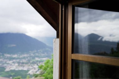 arkaplanda dağlar ve meran ile açık pencere
