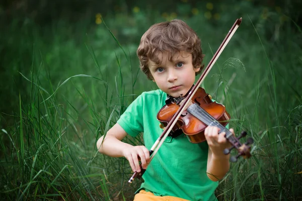 곱슬머리의 재능있는 소년은 속에서 바이올린을 — 스톡 사진