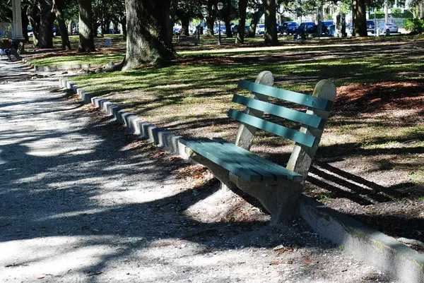 Güneşli bir günde yalnız, boş bir bankta.