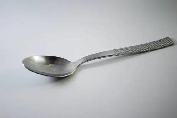 Beyaz arka planda tek bir gümüş kaşık