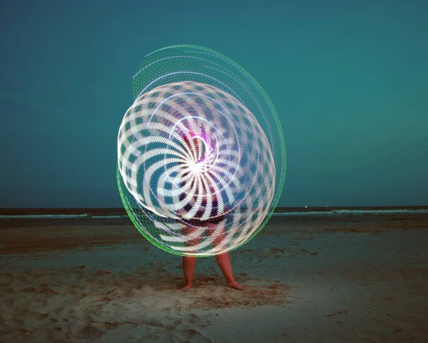 LED halkayla zıplayan bir kızın uzun pozları.