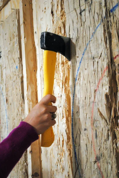 Tahtaya gömülü baltayı tutan bir el.