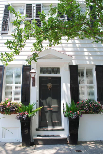 Beyaz bir evin siyah ön kapısı.