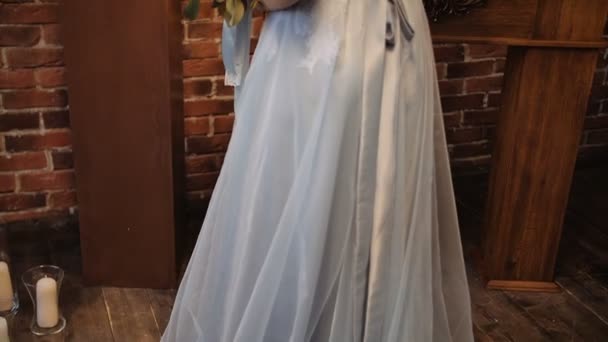 Brud i snygg Serenity klänning med en bouqet i ett loft utrymme — Stockvideo