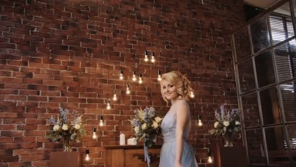 Невеста в стильном платье спокойствия с букетом в мансарде — стоковое видео