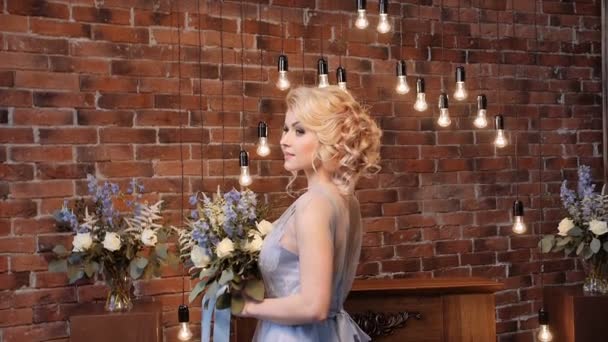 Braut im stilvollen Kleid der Gelassenheit mit einem Strauß im Loftbereich — Stockvideo