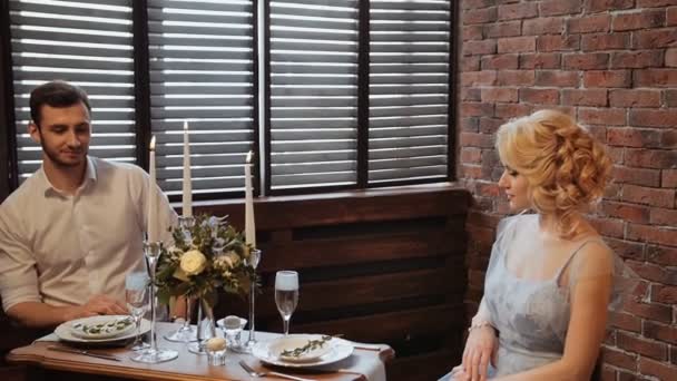 婚礼。装饰。服务。艺术品。新娘和新郎在一个西装坐在服务表上的砖和百叶窗的背景 — 图库视频影像