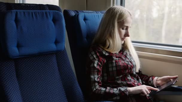 Jovem mulher usando tablet enquanto viaja de trem — Vídeo de Stock