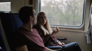 Genç çift tren, sandviçini ye ve tarama için tablet kullanma