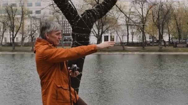 Hombre adulto fotógrafo decir cómo posar y tomar fotos con la vieja cámara de cine vintage — Vídeos de Stock