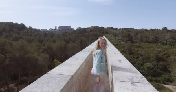 Tourist girl walk thru the ancient devils aqueduct — Stock Video