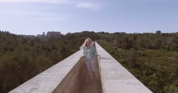 Toeristische meisje lopen via het oude duivels aquaduct — Stockvideo