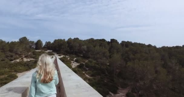 Туристическая девушка ходить через древние дьяволы акведук — стоковое видео