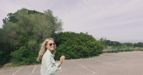 Linda menina adolescente caminha sobre o estacionamento — Vídeo de Stock