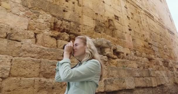 Mulher bonita falando foto com câmera de filme retro velho de construção antiga — Vídeo de Stock