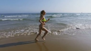 güzel bir kız sahilde onu bikini içinde çalışır.