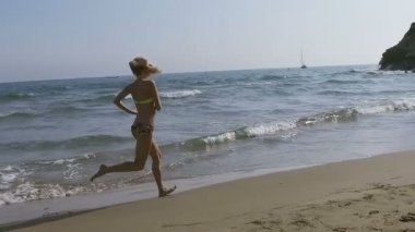 güzel bir kız sahilde onu bikini içinde çalışır.