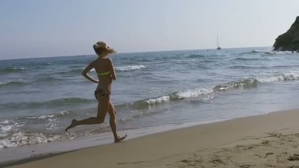Красивая девушка бежит по пляжу в бикини — стоковое видео