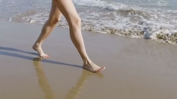 Una hermosa chica corre en la playa en bikini — Vídeo de stock