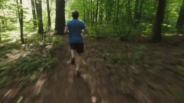 Homme adulte courir le jogging en plein air dans une nature forestière sur un sentier forestier et en profiter et regarder heureux 