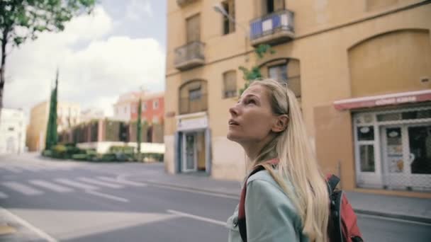 Jong meisje met rugzak wandeling door de straten in slow motion — Stockvideo