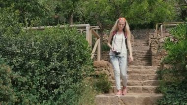 Retro kamera ile genç kadın parkta fotoğraf çekmek