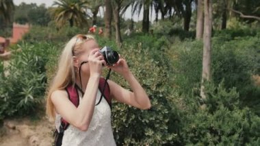 Retro kamera ile genç kadın parkta fotoğraf çekmek