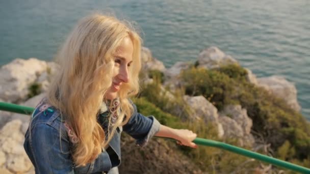 Chica rubia romántica sonrisa y risa. Vista de la costa cerca de la playa — Vídeos de Stock