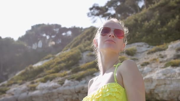 Vacanza estiva donna divertendosi sulla spiaggia passeggiando rilassandosi al sole indossando bikini e occhiali da sole aviatore — Video Stock