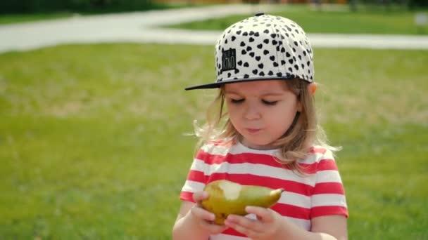 Sunny girl med päron lyckligt äter frukt — Stockvideo