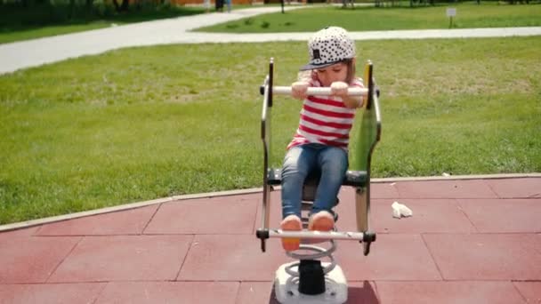 Menina criança jogar em um parque sentar-se no balanço — Vídeo de Stock