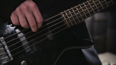 Adam gitar çalıyor. Konser rock grubu sahne alanı'nda gerçekleştiriliyor. Yavaş hareket saz