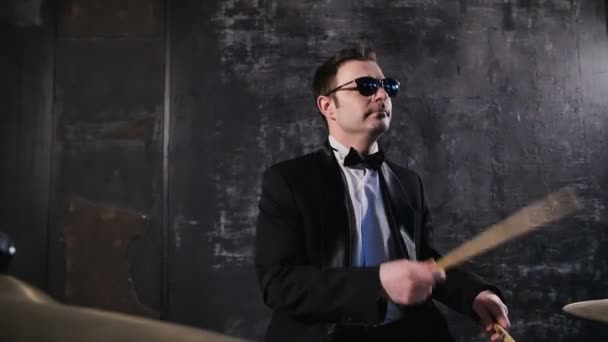 El hombre de traje negro y gafas de sol toca el tambor. Banda de covers de rock actuando en el escenario con el baterista — Vídeo de stock