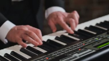 Eller bir adam, synthesizer oynarken