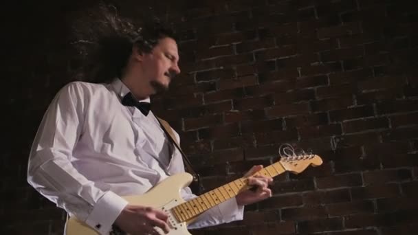 남자는 기타를 재생합니다. 무대에서 공연 콘서트 록 밴드입니다. 슬로우 모션 악기 연주 — 비디오