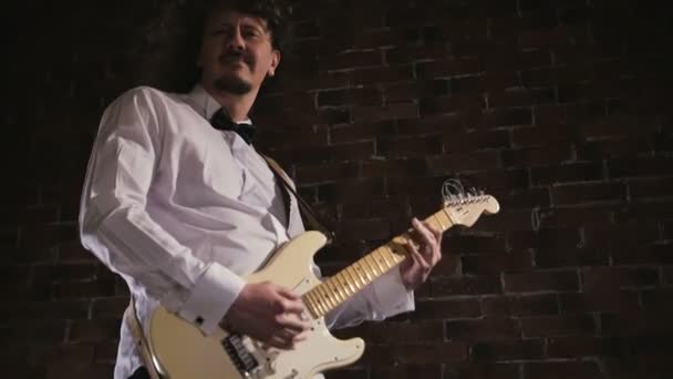 남자는 기타를 재생합니다. 무대에서 공연 콘서트 록 밴드입니다. 슬로우 모션 악기 연주 — 비디오