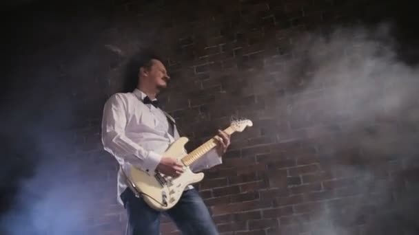 Mann spielt Gitarre. Konzert-Rockband auf der Bühne. Zeitlupenspiel — Stockvideo