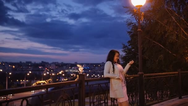 Attractive casually dressed couple enjoy a romantic stroll alongside the city view. Woman gestures man to come — Stock Video