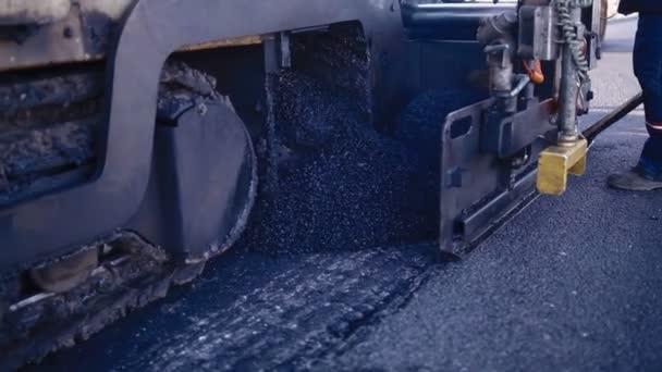 Pavé d'asphalte application d'asphalte sur la route. Un équipement utilisé pour appliquer l'asphalte sur la rue automatiquement. Un énorme équipement lourd mettre des asphaltes sur la route. — Video