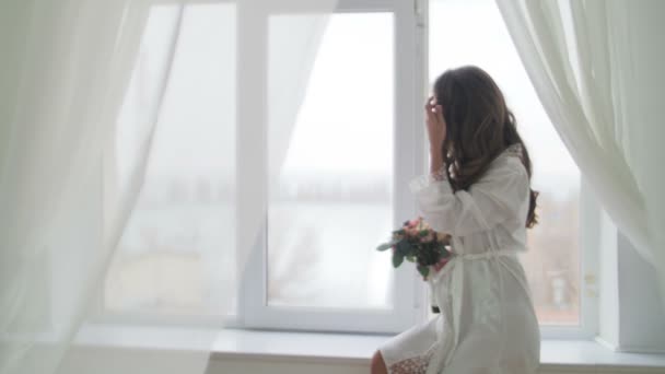 Jonge vrouw permanent op het venster — Stockvideo
