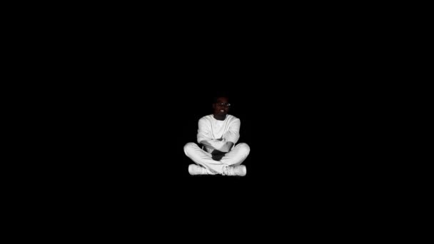 Photo of an insane black man in his forties wearing a straitjacket sitting in a dark of an asylum — Stock Video