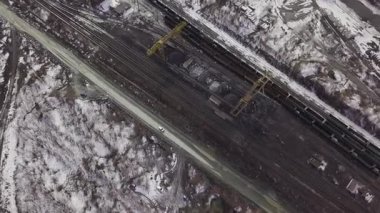 Çimen ve ağaçlarla çevrili, lastik izleri olan karla kaplı bir otoyolun havadan görünüşü. Otomotiv lastikleri ve bisiklet lastikleri yolda görülebilir.