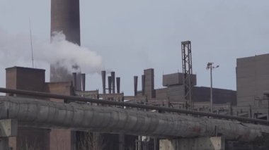 Kirlilik, şehirdeki bir sanayi binasının bacasından yükselen duman dalgalarının, zararlı gaz emisyonlarıyla gökyüzünü ve suyu etkilemesi gibi belirgindir.